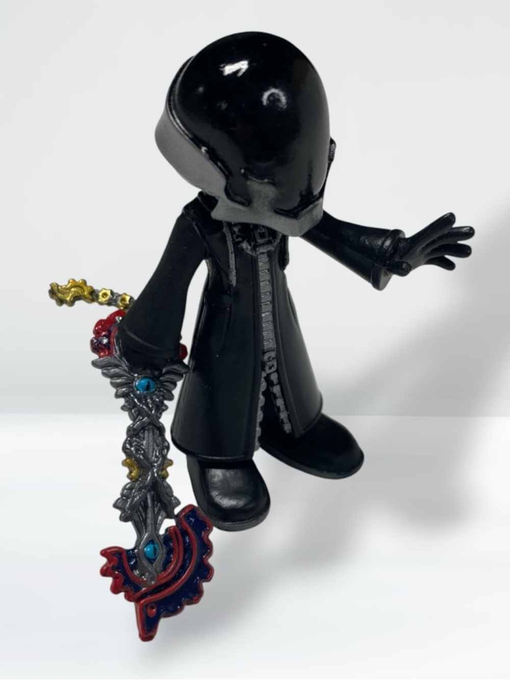 Black Hooded Figure Vinyl Collectible with Ornate Keyblade